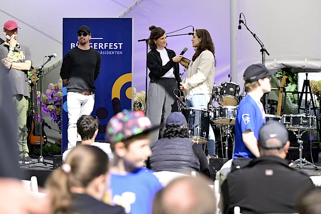 Auch das Bühnenprogramm konnte die HanseMerkur mit gestalten. Im Interview Marie Mävers (r.), HanseMerkur,  sowie ROCK KIDS e.V.-Gründer Peter Achner (l.) und Micha Holland (2.v.l.).